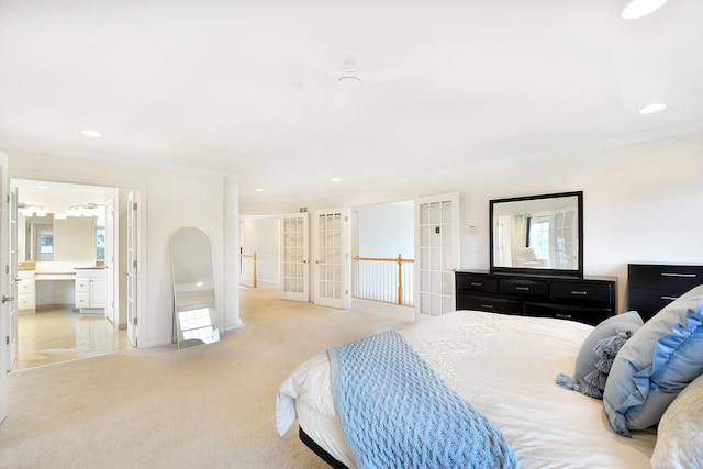 bedroom with ensuite bathroom, light colored carpet, crown molding, and french doors