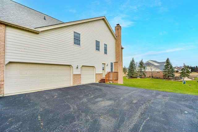 view of home's exterior with a garage and a lawn