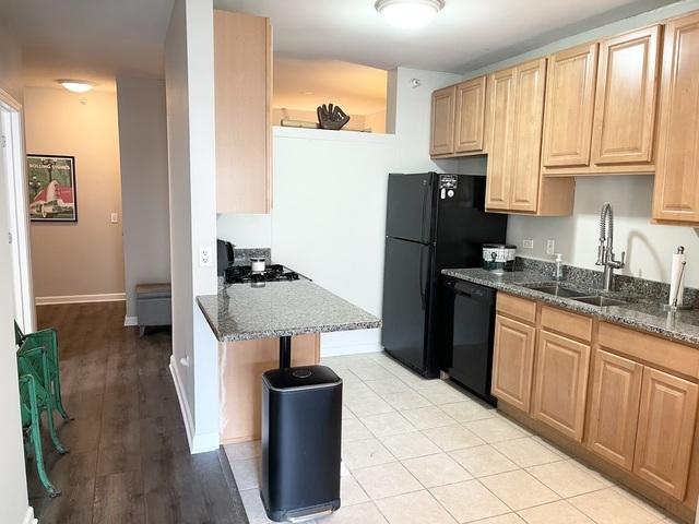 kitchen featuring sink, ceiling fan, appliances with stainless steel finishes, dark stone countertops, and a kitchen breakfast bar