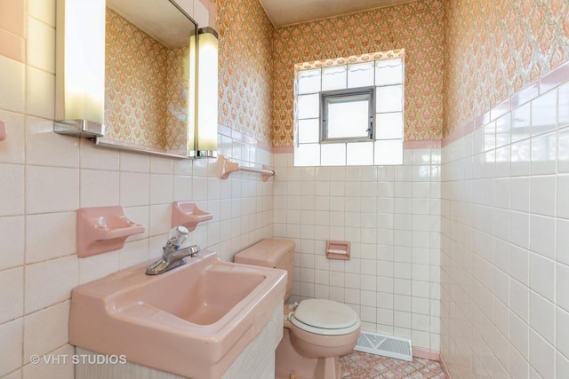 bathroom with sink, tile walls, tile patterned floors, and toilet