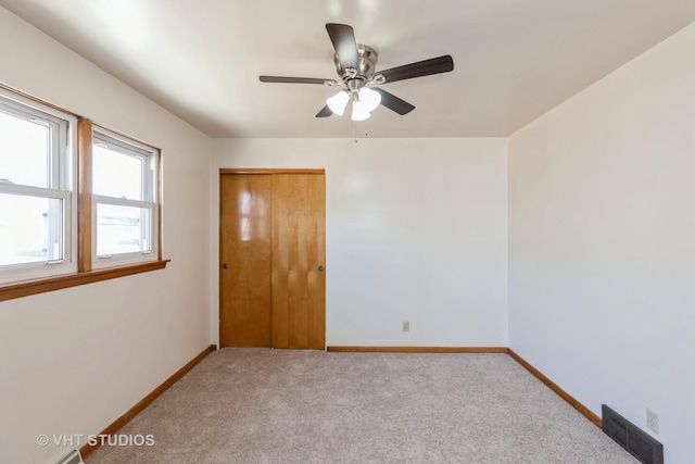 unfurnished room featuring light carpet and ceiling fan