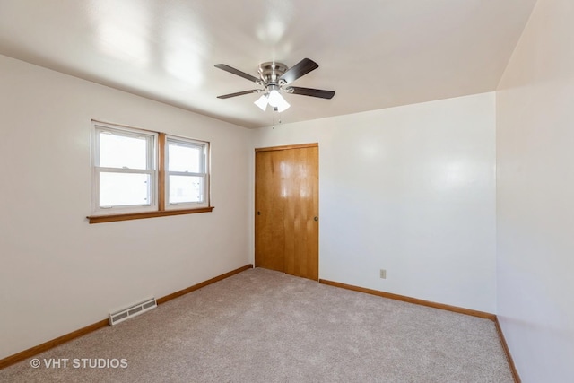 carpeted spare room featuring ceiling fan