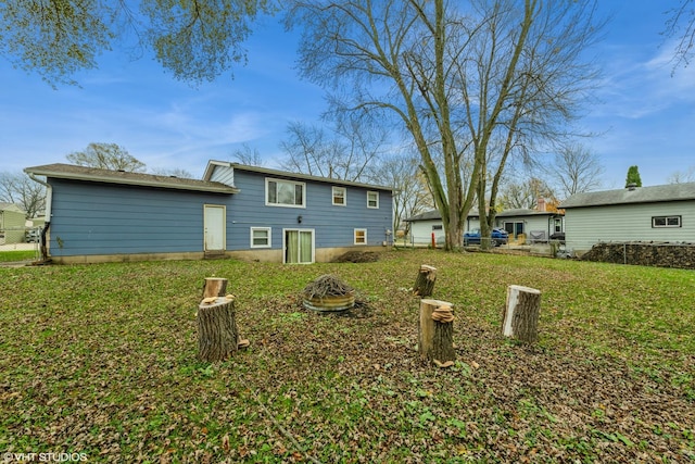 rear view of house featuring a yard and a fire pit