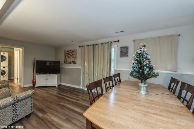 dining space with stacked washer and dryer and wood-type flooring