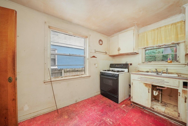 kitchen with gas range, ornamental molding, and a wealth of natural light