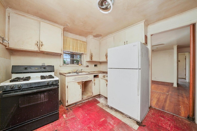 kitchen with white refrigerator, gas range, and sink