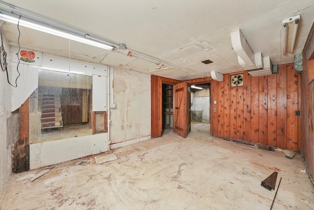 unfurnished room featuring wooden walls