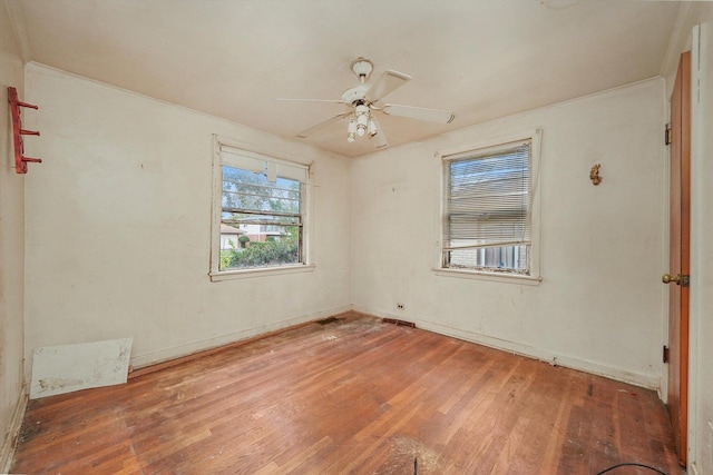 empty room with hardwood / wood-style flooring, ceiling fan, and ornamental molding