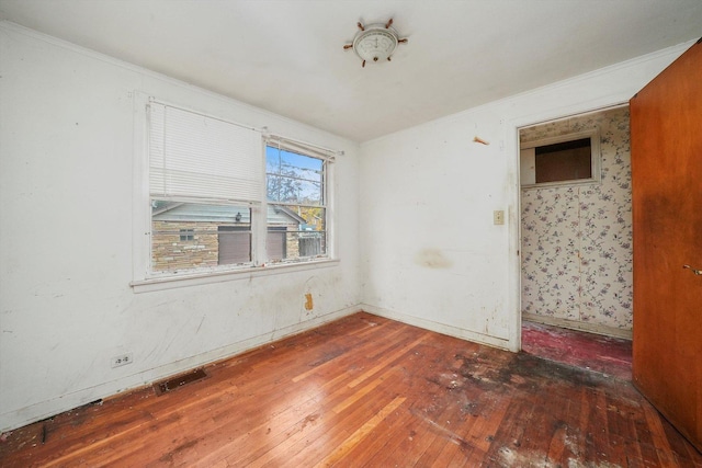 empty room with crown molding and dark wood-type flooring