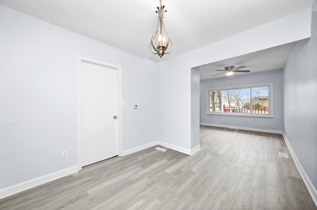 unfurnished room featuring a chandelier and light hardwood / wood-style flooring