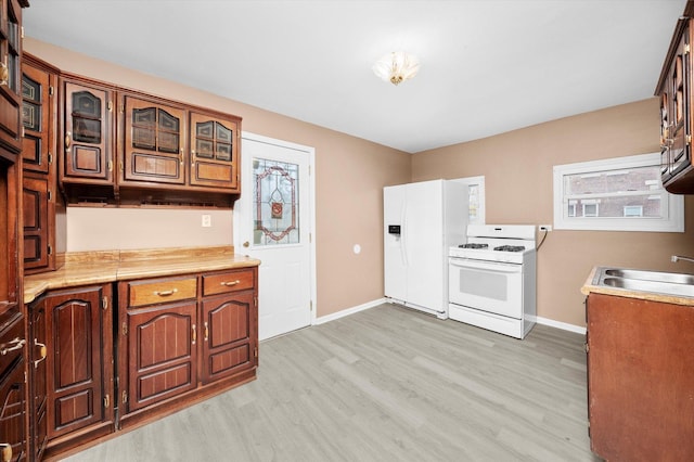 kitchen featuring sink, white appliances, and light wood-type flooring