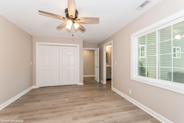 unfurnished bedroom with light hardwood / wood-style floors, ceiling fan, and a closet