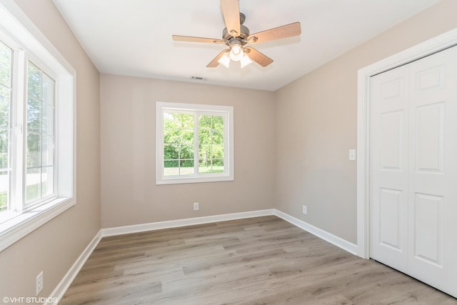 unfurnished room with ceiling fan, a healthy amount of sunlight, and light hardwood / wood-style floors