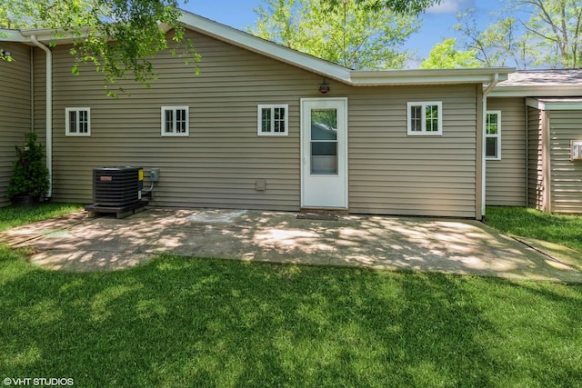 rear view of property with a patio, a yard, and central air condition unit