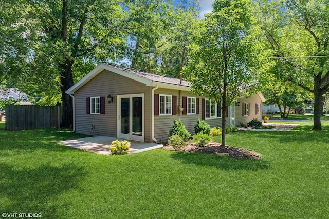 back of property with a yard and a patio area