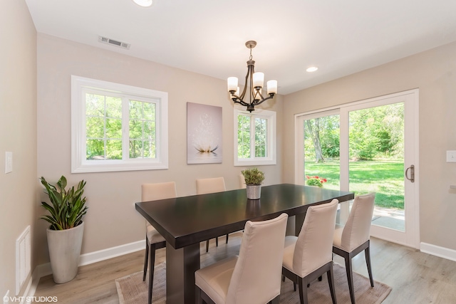 dining room featuring an inviting chandelier, light hardwood / wood-style floors, and a wealth of natural light