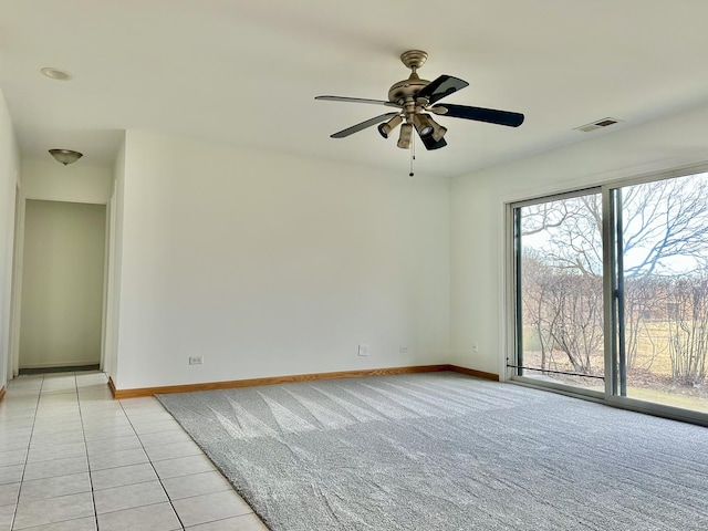 tiled empty room featuring ceiling fan