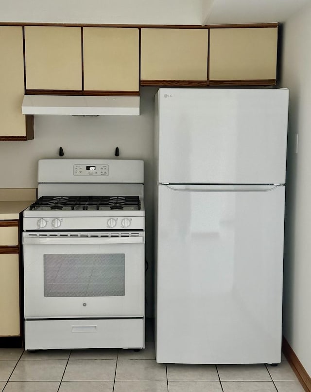 kitchen with extractor fan, white appliances, and light tile patterned flooring