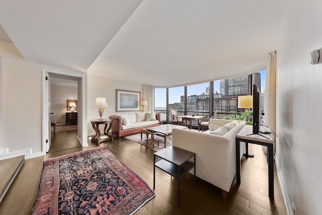 living room with a wall of windows, dark wood finished floors, and baseboards