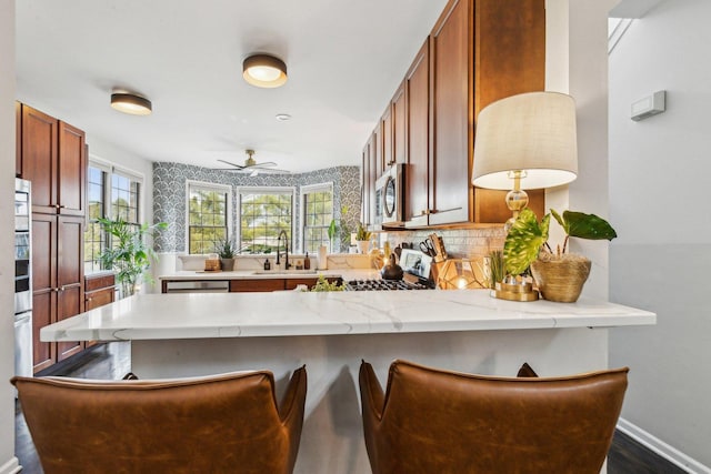 kitchen with plenty of natural light, kitchen peninsula, sink, and stove