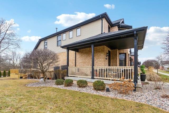 exterior space featuring covered porch and a front yard