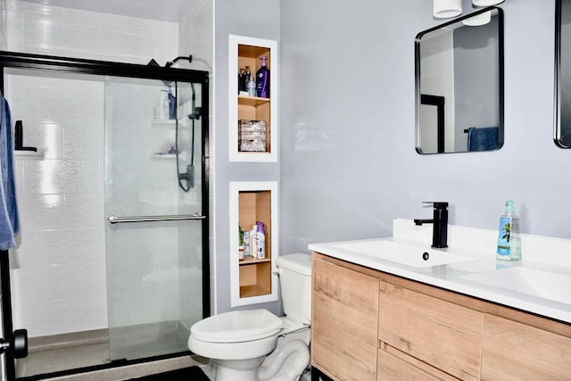 bathroom featuring vanity, toilet, and an enclosed shower