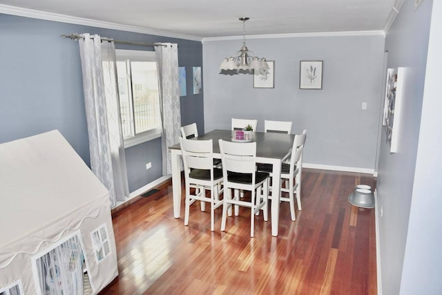 dining space featuring ornamental molding, dark hardwood / wood-style floors, and an inviting chandelier