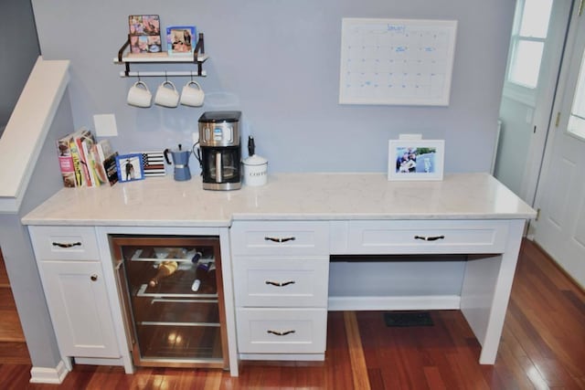 bar with white cabinetry, wood-type flooring, light stone countertops, and beverage cooler