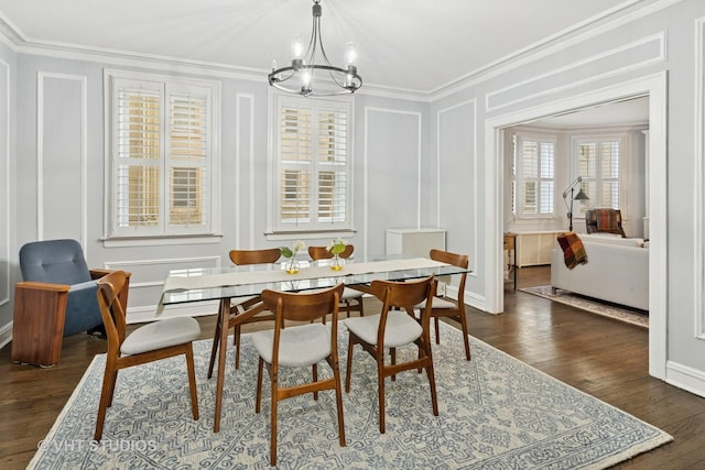 dining space with a notable chandelier, ornamental molding, dark wood finished floors, and a decorative wall