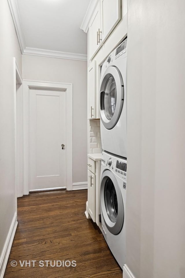 laundry room with ornamental molding, cabinet space, dark wood finished floors, and stacked washing maching and dryer