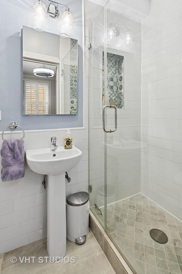 full bathroom featuring a stall shower and tile walls