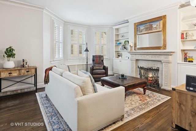 living room featuring dark wood-type flooring, a warm lit fireplace, ornamental molding, and built in shelves