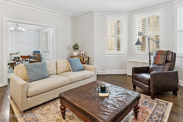 living room featuring a chandelier, baseboards, wood finished floors, and crown molding