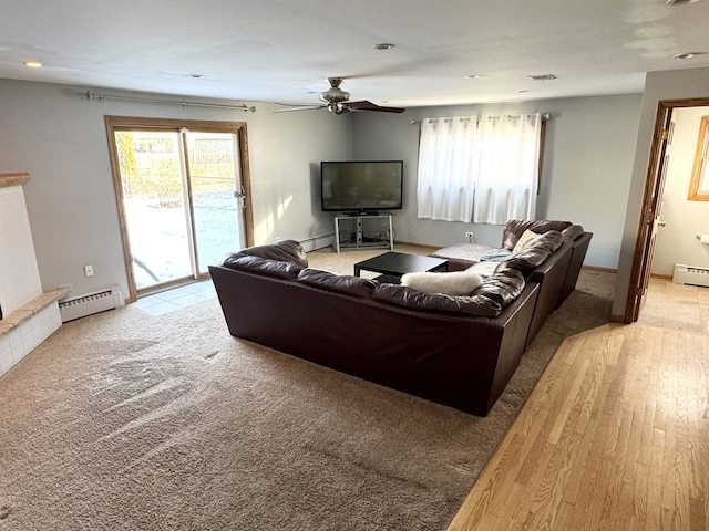 living room with ceiling fan, light hardwood / wood-style floors, and a baseboard heating unit