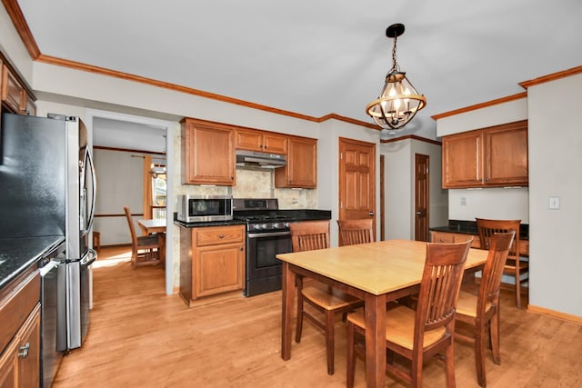 kitchen featuring crown molding, decorative light fixtures, light hardwood / wood-style flooring, a notable chandelier, and stainless steel appliances