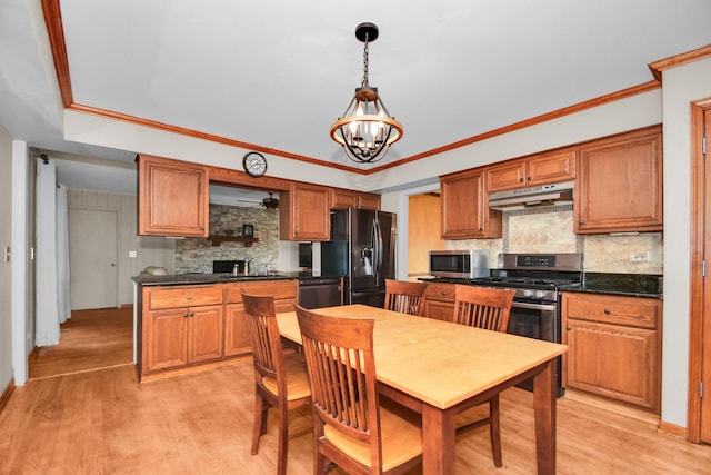 kitchen with sink, tasteful backsplash, hanging light fixtures, light wood-type flooring, and appliances with stainless steel finishes