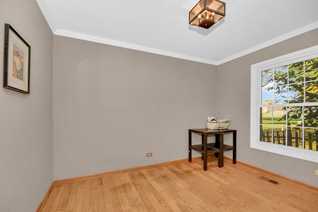 empty room with crown molding and light wood-type flooring