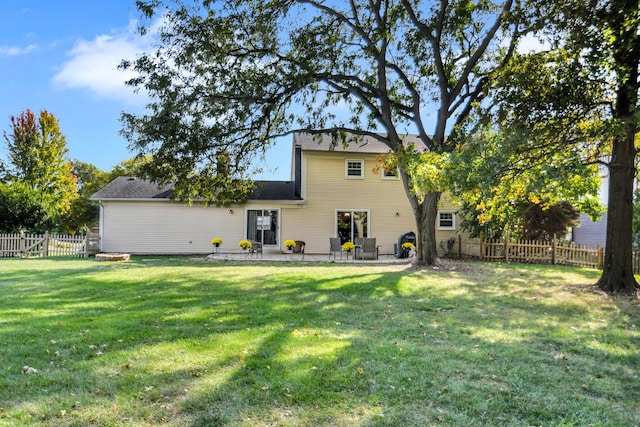 back of house with a patio and a lawn