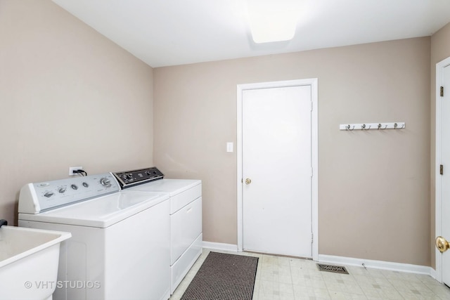 washroom with separate washer and dryer and sink