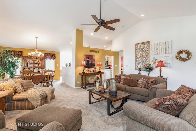 carpeted living room with ceiling fan with notable chandelier and high vaulted ceiling