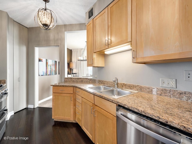 kitchen featuring pendant lighting, light countertops, appliances with stainless steel finishes, light brown cabinets, and a sink