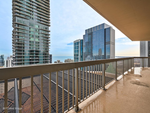 balcony featuring a water view and a city view