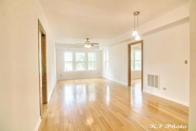 empty room with ceiling fan and light hardwood / wood-style floors