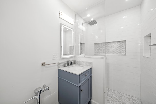 bathroom featuring a tile shower and vanity