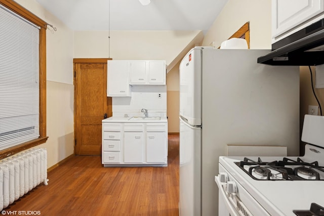 kitchen with white range with gas stovetop, white cabinetry, tasteful backsplash, light hardwood / wood-style flooring, and radiator heating unit