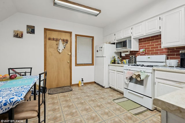 kitchen with white cabinetry, white appliances, lofted ceiling, and decorative backsplash