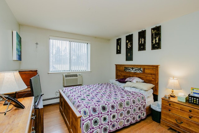 bedroom featuring light hardwood / wood-style flooring, a wall unit AC, and baseboard heating