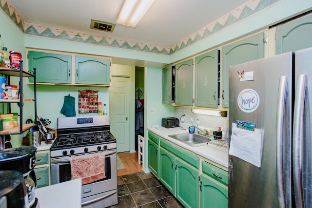 kitchen featuring sink, backsplash, stainless steel appliances, and green cabinetry