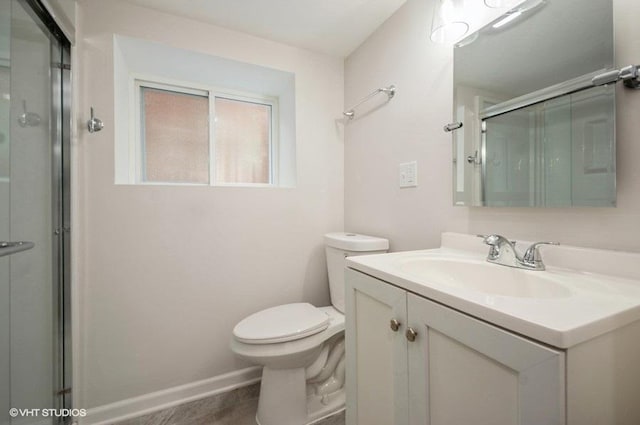 bathroom with vanity, a shower with shower door, and toilet