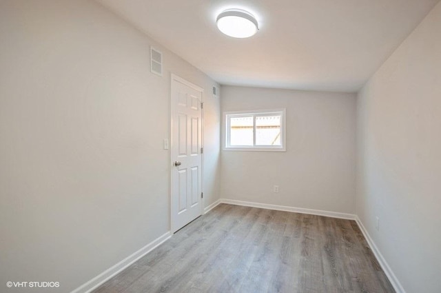 empty room with lofted ceiling and light wood-type flooring